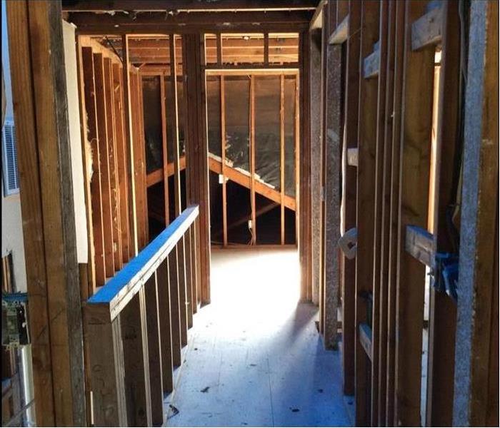 Inside of a home showing all drywall removed and only studs remaining